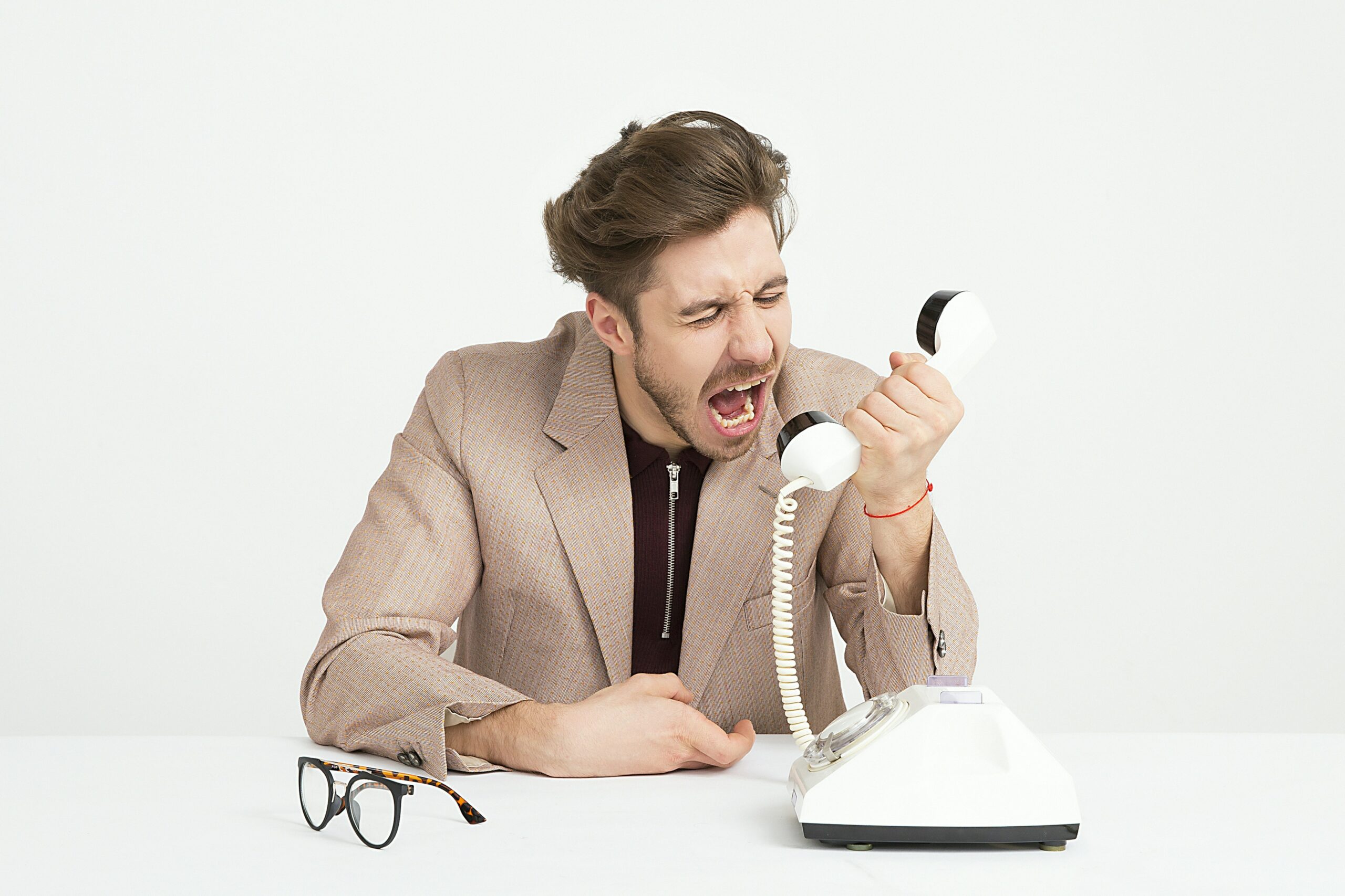 homme agacé par démarchage téléphonique arnaques rénovation énergétique